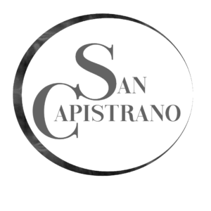 Grey circle on pastel grey background, In circle are the words San Capistrano. Logo for the San Capistrano series by Angelique Jurd 